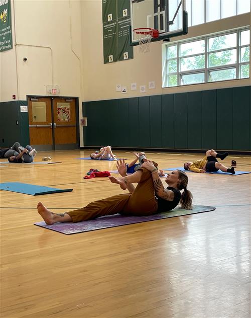 Instructor stretching on the gymnasium floor